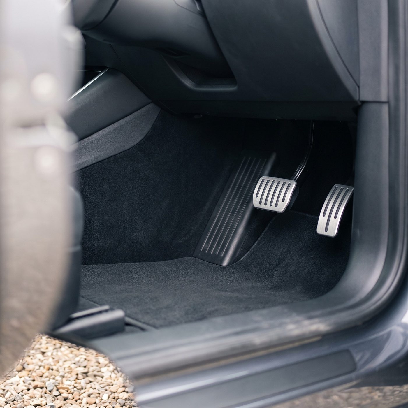 The driver’s footwell of a car, seen through the open door