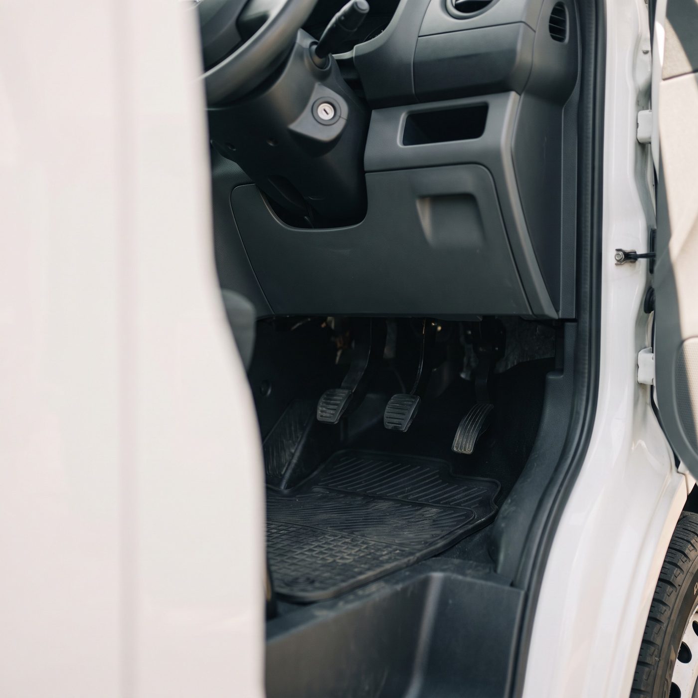 The driver’s footwell of a work vehicle, seen through the open door